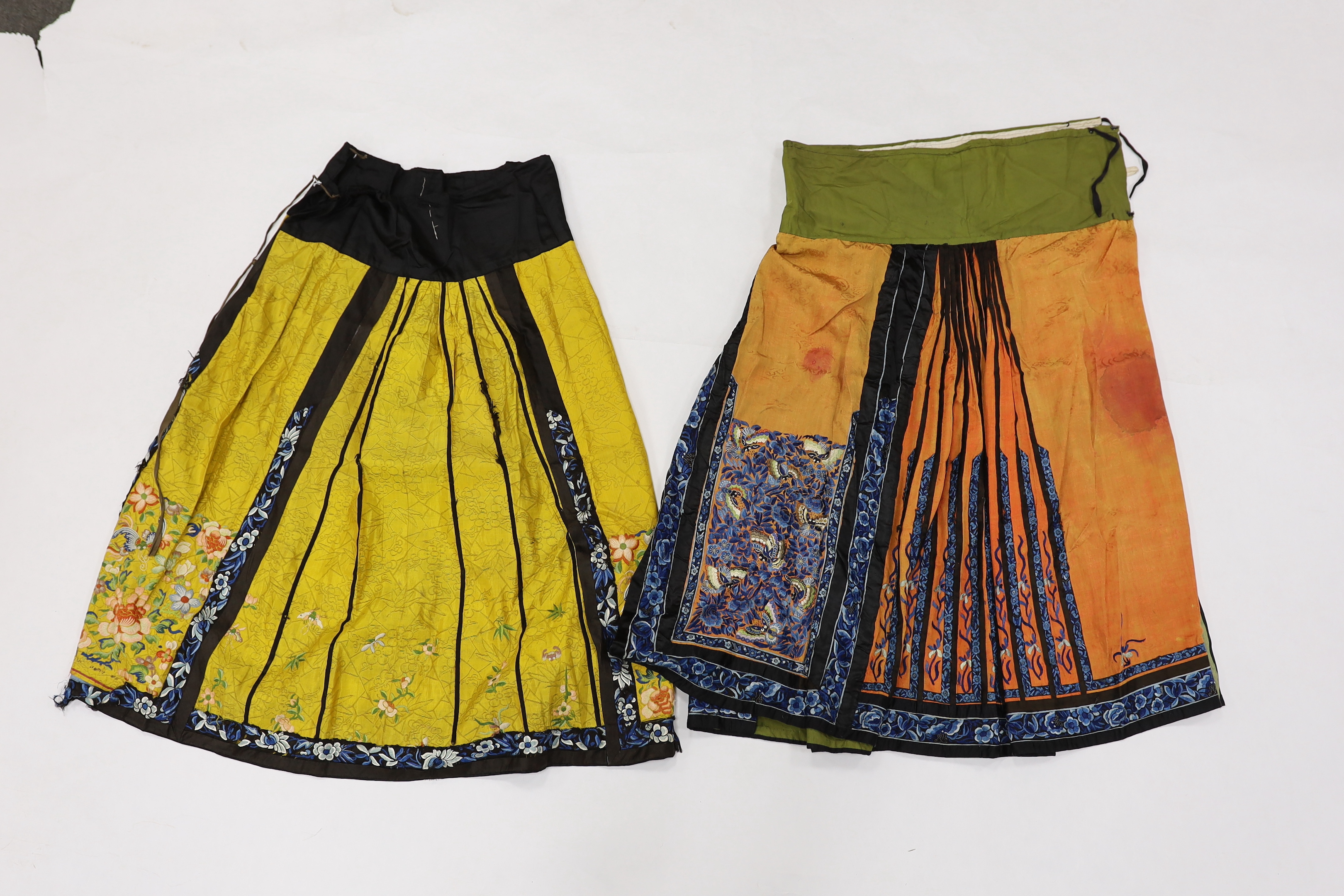 A late Chinese Qing yellow silk damask wedding skirt, with polychrome coloured silk embroidery, together with a similar coral silk damask blue embroidered wedding skirt